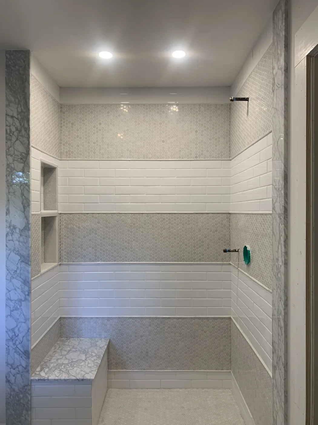 Tile shower with a built in bench and horizontal accent band