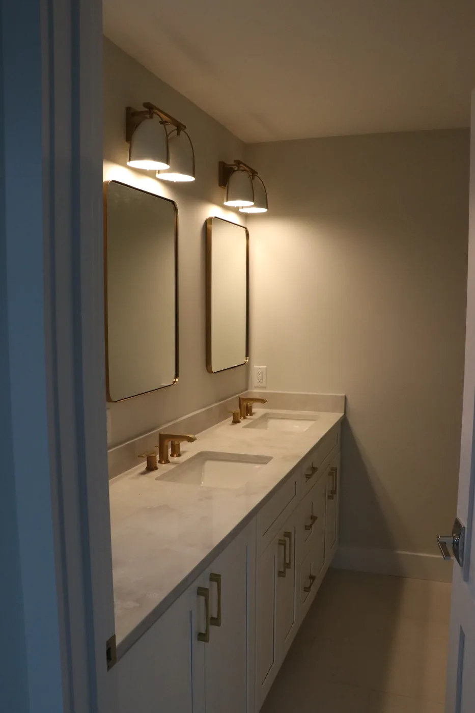 Double vanity with brass fixtures and deep blue walls