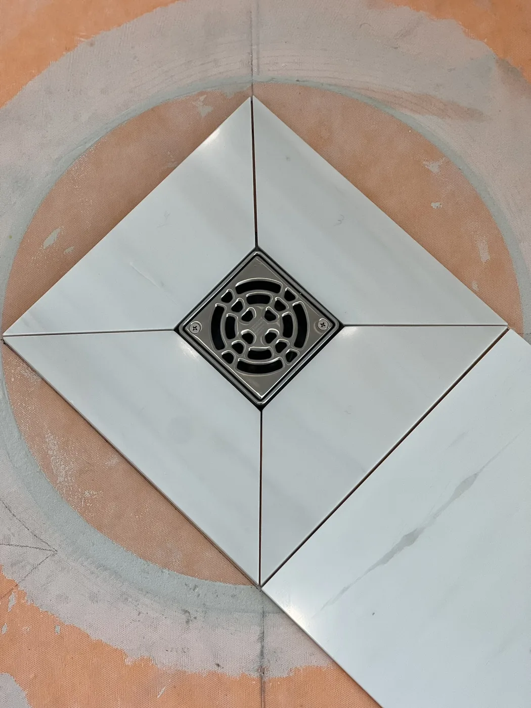 Shower drain set into a diamond tile inlay before the floor tile goes in