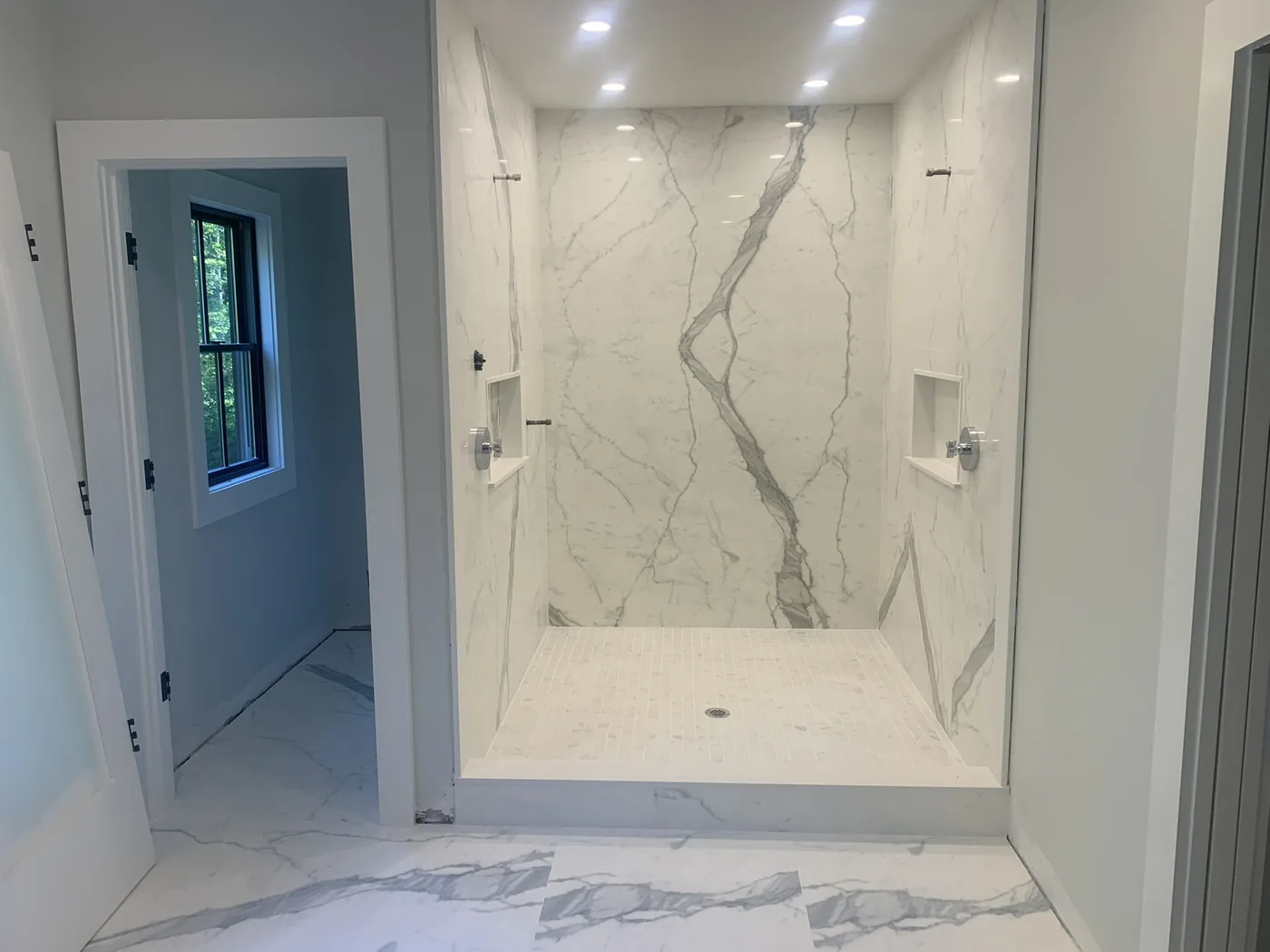 Walk in shower finished in large format marble look tile