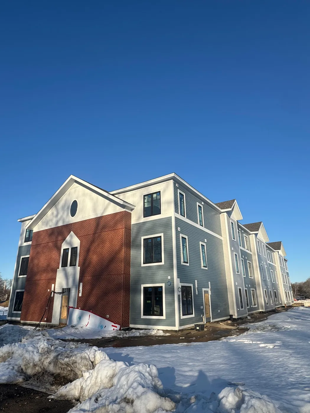 Exterior siding work in progress on an apartment building