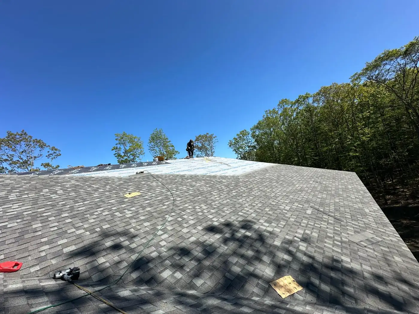 Roof underlayment and shingle work on a residential roof