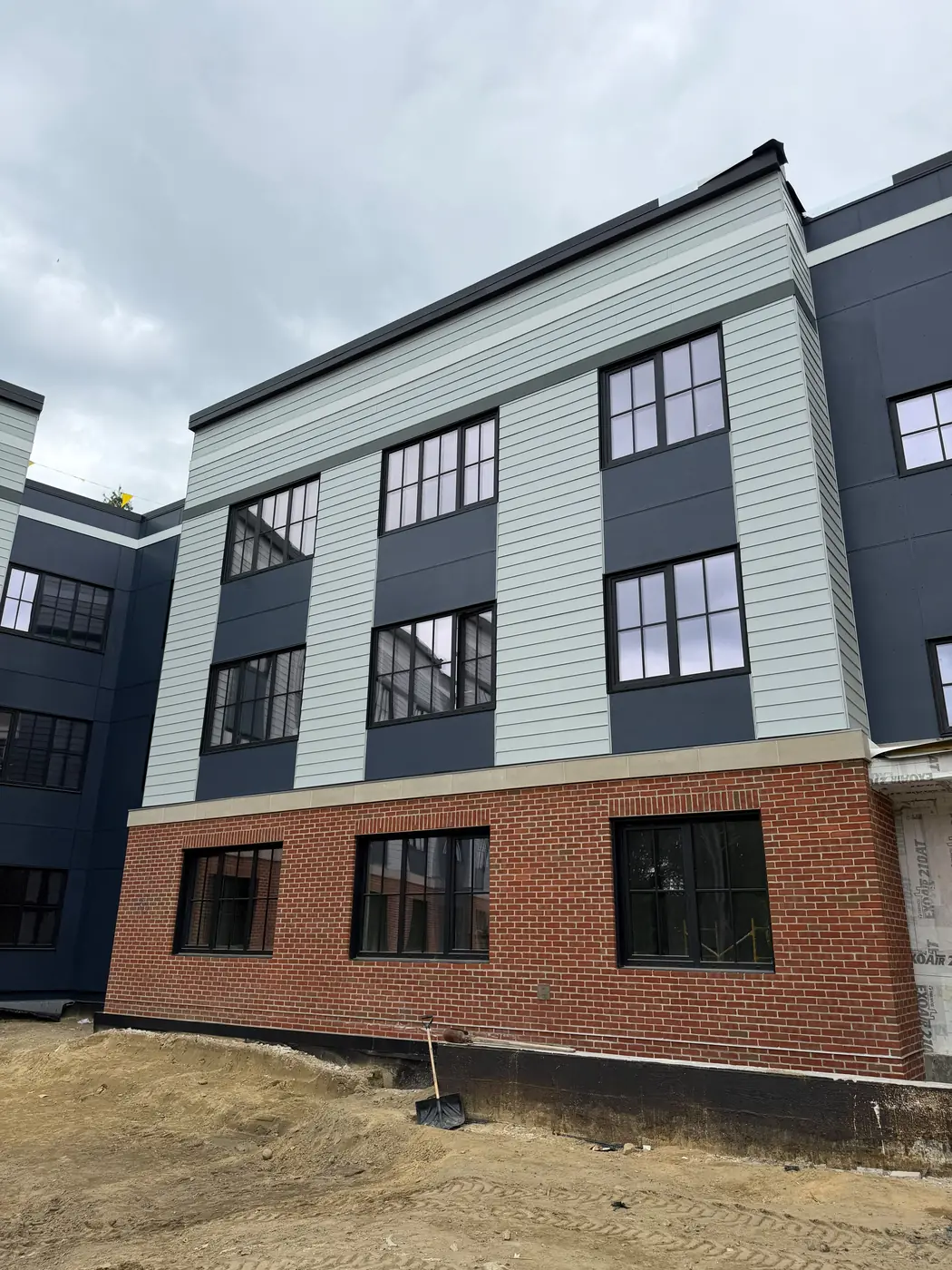 Corner view of a multifamily exterior with mixed siding and brick
