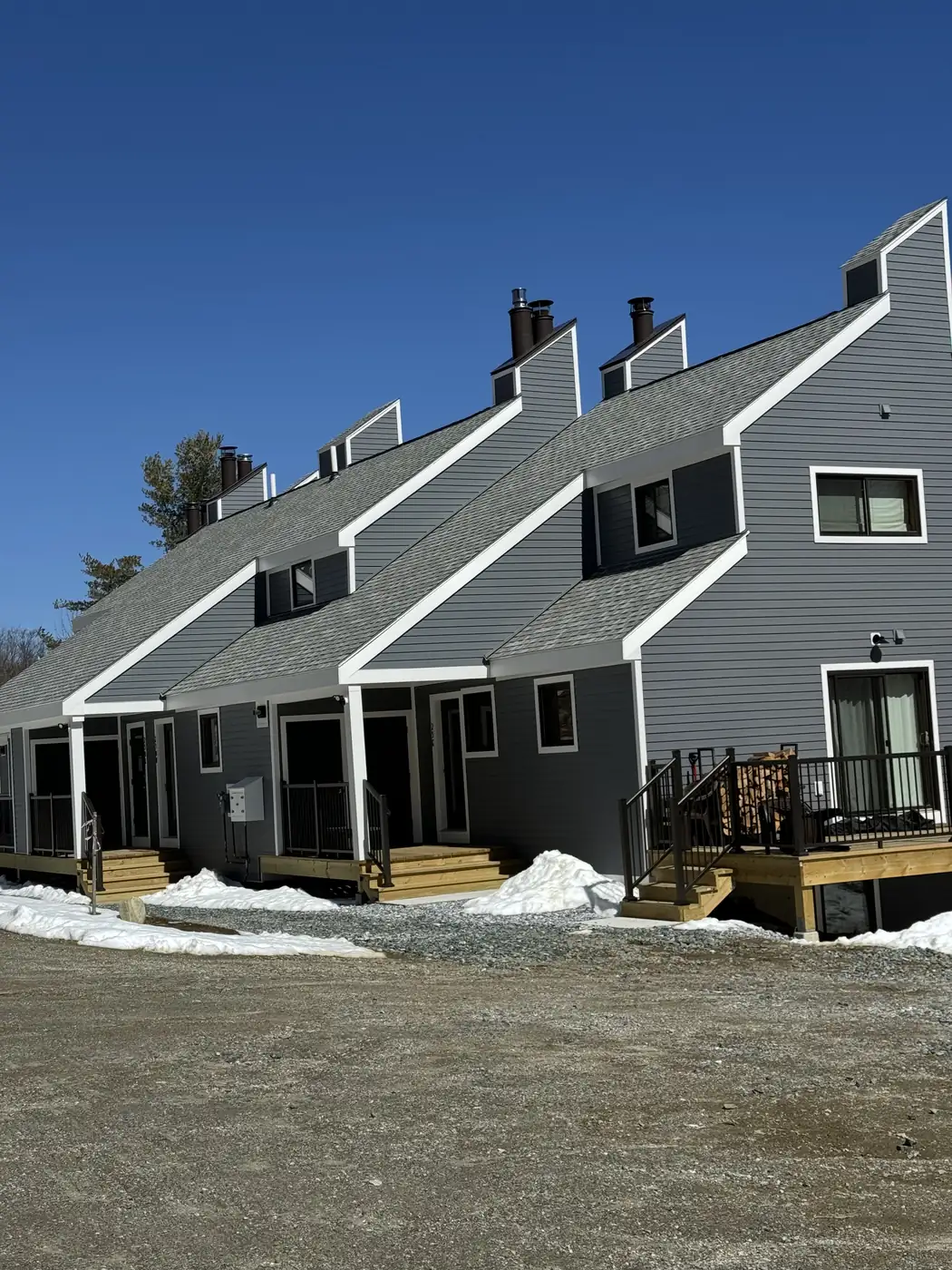 Gray sided townhomes with white trim in winter